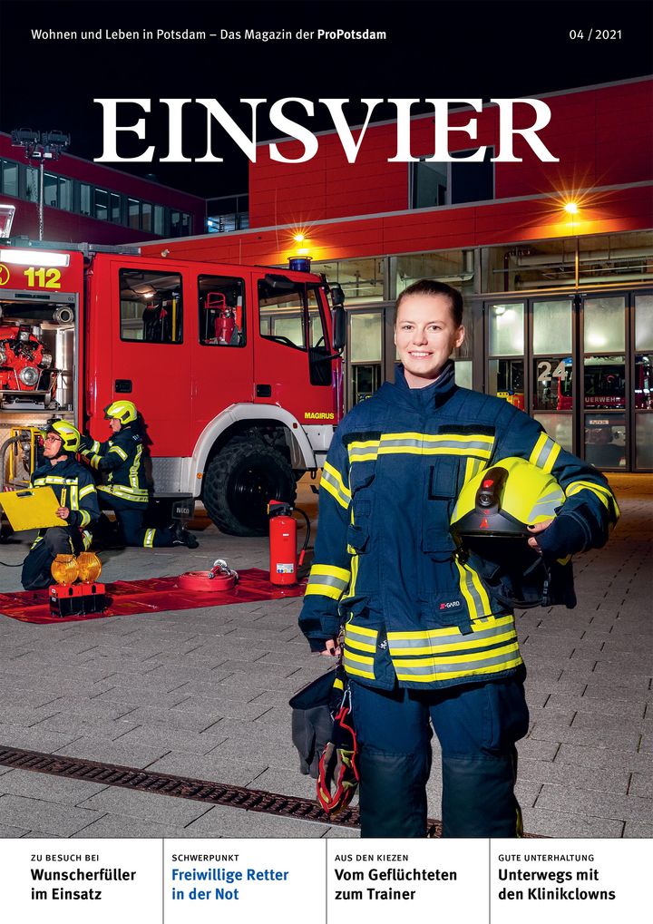 Magazintitel der EINSVIER mit Feuerwehrfrau im Vordergrund und Feuerwehrfahrzeug im Hintergrund bei Nacht