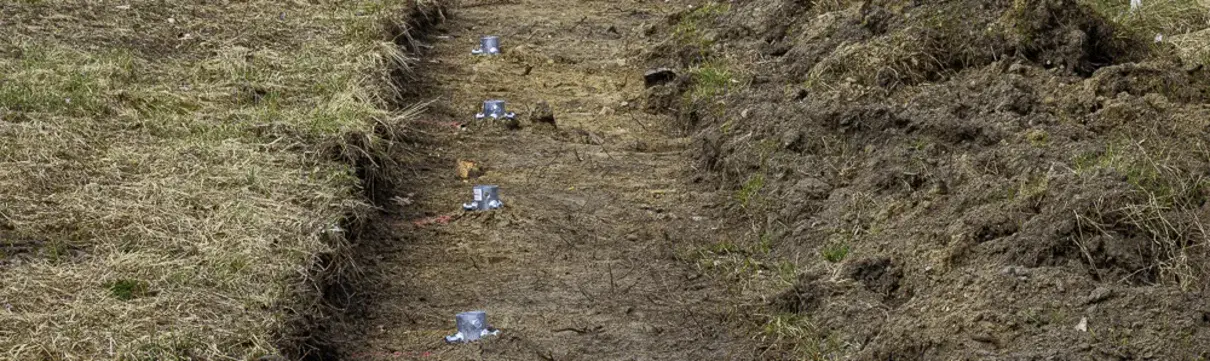 Blick auf Wiesenstreifen mit Zaunpfahlfundamenten. Eindruck der Baumaßnahmen zur Errichtung des Katzenschutzzaunes im Stadtquartier Krampnitz.