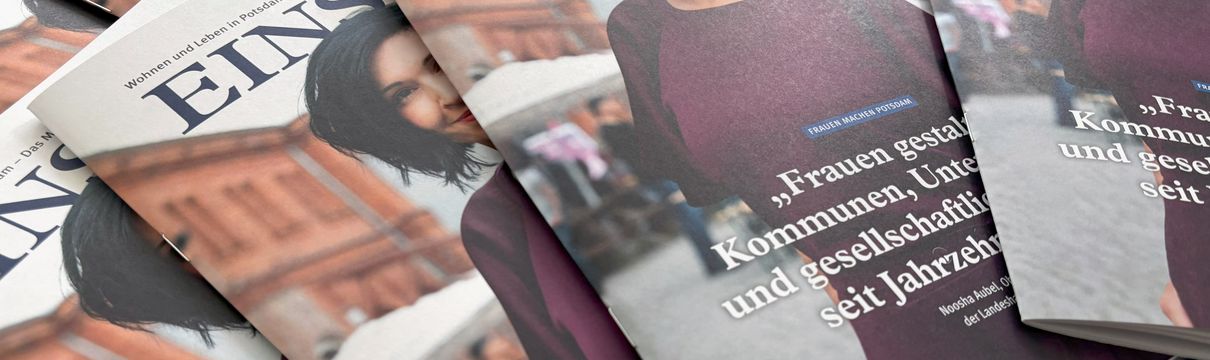 Mehrere Magazine liegen aufgefächert auf einem Tisch. Auf dem Titelbild ist eine Frau mit dunklen Haaren und einem lilafarbenen Kleid zu sehen.