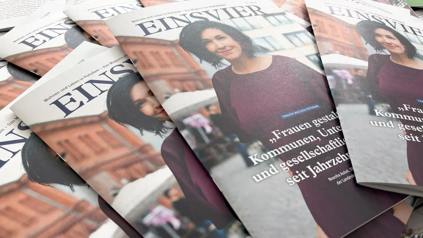Mehrere Magazine liegen aufgefächert auf einem Tisch. Auf dem Titelbild ist eine Frau mit dunklen Haaren und einem lilafarbenen Kleid zu sehen.