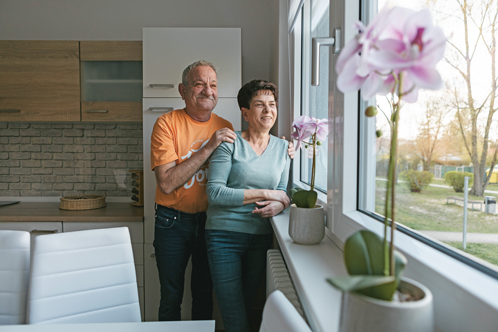 Christian und Silvia Märzluft schauen in ihrer Wohnung aus dem Fenster.