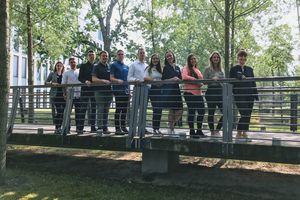 Gruppenbild junger Leute, die nebeneinander am Geländer eine Brücke stehen.