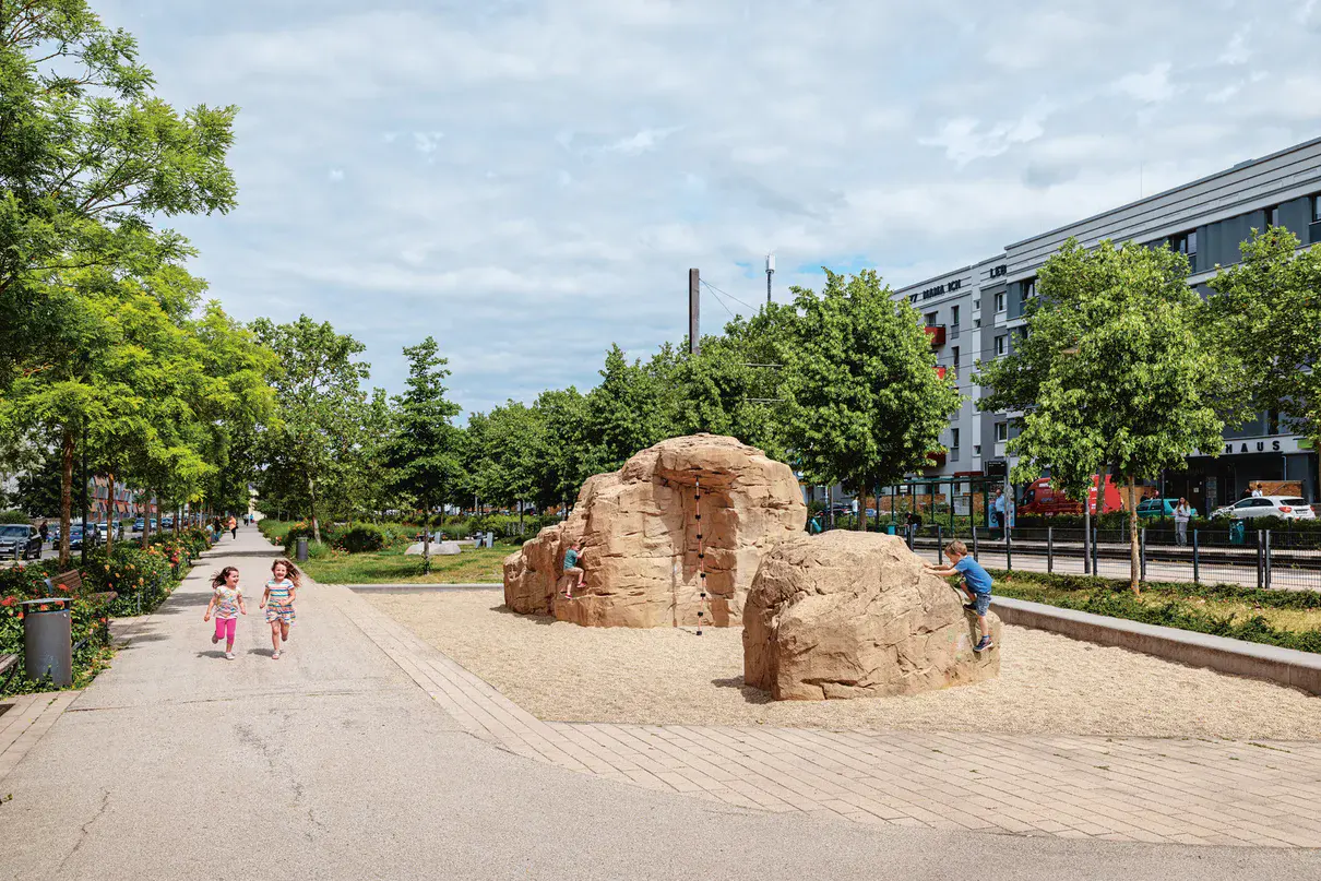 Ein Kletterfelsen mit spielenden Kindern in einem Wohngebiet
