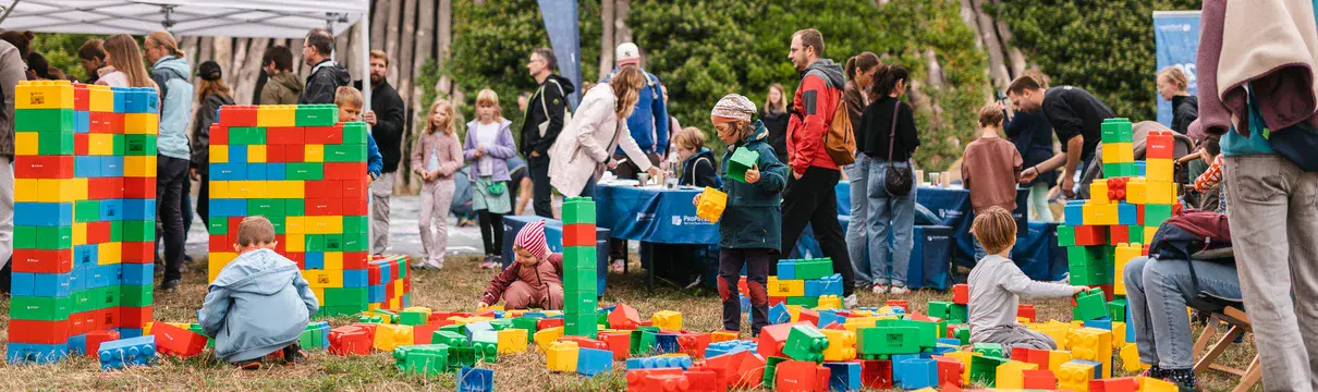 Spiel- und Mitmachbereich mit XXL-Bausteinen für Kinder bei einem Familienfest im Park.