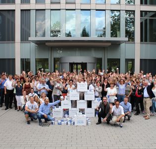 Gruppenbild der ProPotsdam-Mitarbeiter*innen vor dem Eingang der Firmenzentrale