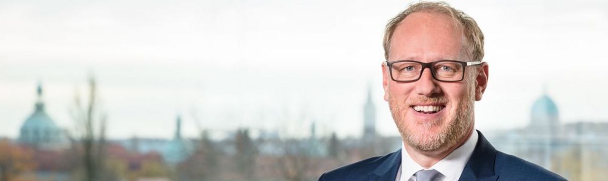 Bert Nicke Bert Nicke, ProPotsdam Geschaeftsführer, in weißem Hemd mit grau meliertem Schlips und blauem Anzug auf der Dachterasse des Firmensitzes. Im Hintergrund ist die Satdtsilhouette Potsdams sichtbar.