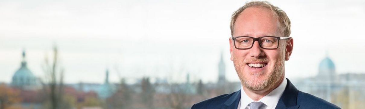 Bert Nicke Bert Nicke, ProPotsdam Geschaeftsführer, in weißem Hemd mit grau meliertem Schlips und blauem Anzug auf der Dachterasse des Firmensitzes. Im Hintergrund ist die Satdtsilhouette Potsdams sichtbar.