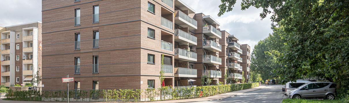 Ein großes mehrstöckiges Wohnhaus mit einer markanten Fassade mit Holz.