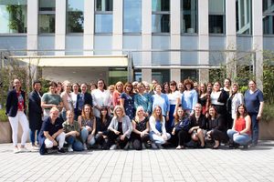 Weibliche Beschäftigte stehen und hocken vor der Zentrale der ProPotsdam