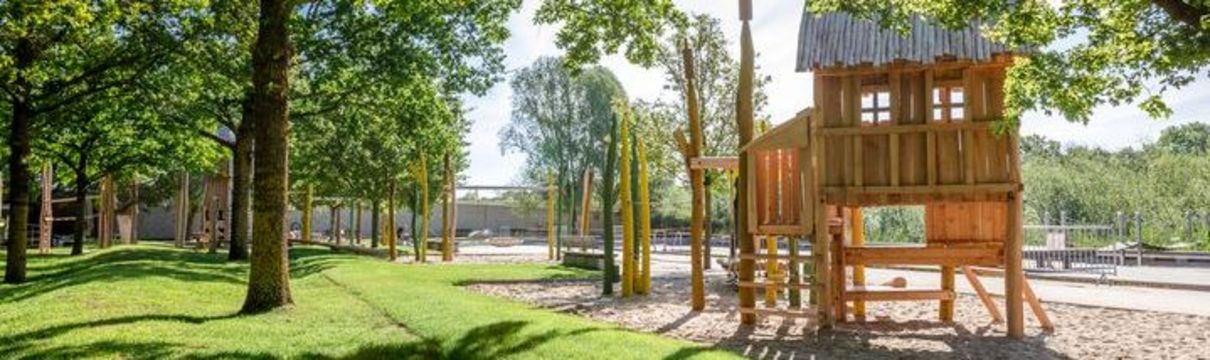 Ein Spielplatz mit Holzelementen unter Bäumen im Volkspark Potsdam