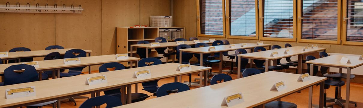 Ein Klassenzimmer in einer Schule mit Tischen und Bänken