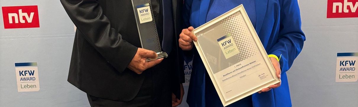 ProPotsdam-Geschäftsführer Jörn-Michael Westphal und die Beigeordnete Brigitte Meier nehmen den KfW Award Leben entgegen.