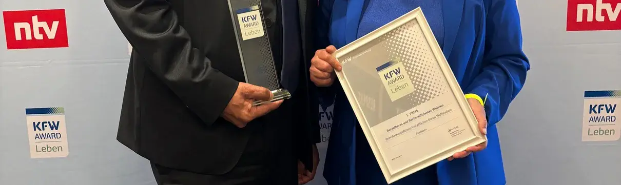 ProPotsdam-Geschäftsführer Jörn-Michael Westphal und die Beigeordnete Brigitte Meier nehmen den KfW Award Leben entgegen.