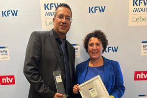 ProPotsdam-Geschäftsführer Jörn-Michael Westphal und die Beigeordnete Brigitte Meier nehmen den KfW Award Leben entgegen.