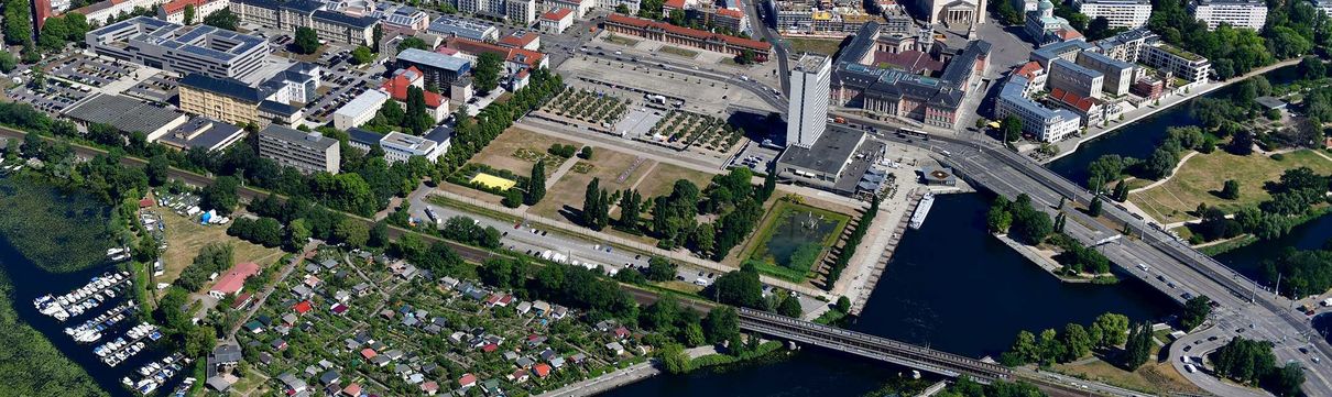 Luftaufnahme über Potsdam. Es sind Häuser, Gewässer und Grün zu erkennen.