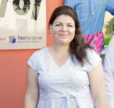 Eine Frau steht vor einem Haus mit einer roten Wand.