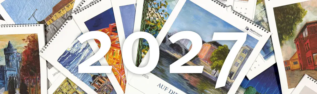 Viele Kalender liegen verstreut auf einem Tisch. In der Mitte steht die Jahreszahl 2027.