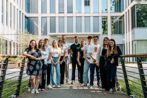Junge Menschen stehen vor einem Gebäude mit Glasfassade.