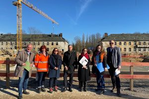 Sieben Menschen, darunter Oberbürgermeister Mike Schubert, Baubeigeordneter Bernd Rubelt und Entwicklungsträger-Potsdam-Geschäftsführer Bert Nicke, stehen vor einer Baustelle in Krampnitz.