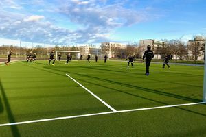 Das Bild zeigt den neuen Kunstrasenplatz im Volkspark, auf dem gerade Fußball gespielt wird.