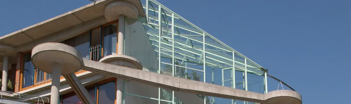 Terrassenhaus Auschnitt des Terrassenhauses mit einer Glasfront und runden Betonteilen.