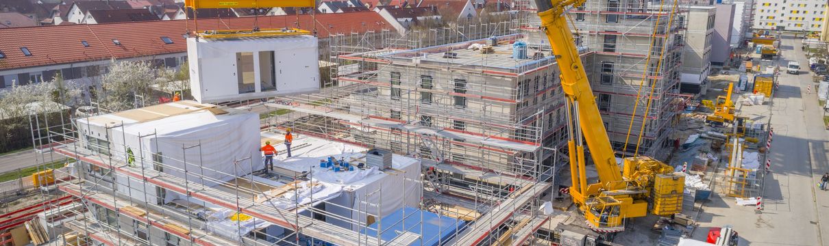 Blick auf Baustelle mit Kran und Baugerüst um neu entstehendes Gebäude