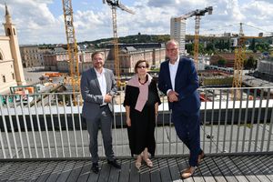 Die Geschäftsführer des Sanierungsträgers Potsdam und der Oberbürgermeister stehen an einer Baustelle. Im Hintergrund sind große Baukräne zu sehen.