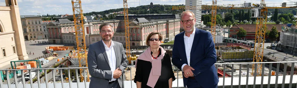 Presserundgang Baufortschritt Potsdamer Mitte (Foto: Petko Beier) Die Geschäftsführer des Sanierungsträgers Potsdam und der Oberbürgermeister stehen an einer Baustelle. Im Hintergrund sind große Baukräne zu sehen.
