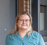 Vor einer Häuserwand stehen ein Mann und eine Frau und schauen in die Kamera.