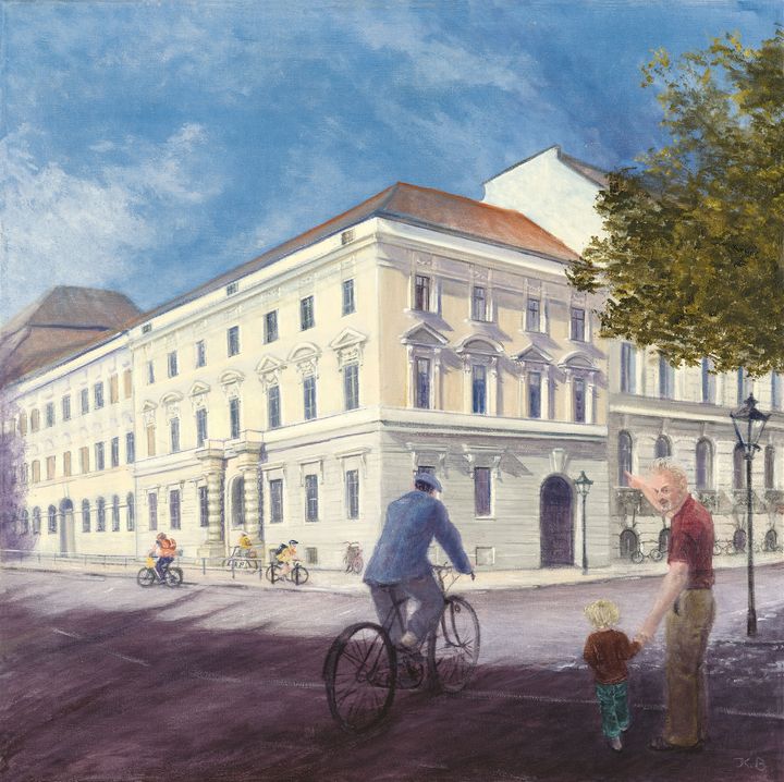 Grundschule Max Dortu - ein weißes, barockes Eckhaus, vor dem ein Radfahrer auf der Straße entlang fährt