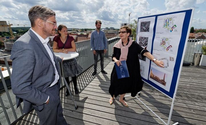Potsdamer Mitte Stadtspaziergang mit dem OBM Eine Frau erläutert das Konzept auf einer Stehwand mit Ausdrucken einigen Zuschauern