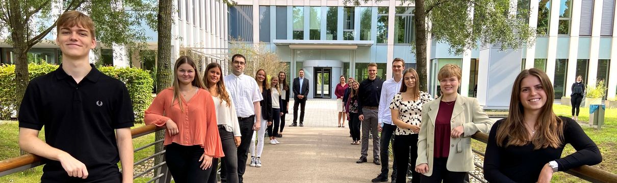 Azubis starten (Foto: Jessica Beulshausen) Junge Erwachsene stehen gereiht links und rechts am Wegesrand.