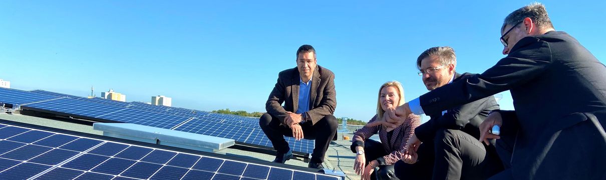 Drei Männer und eine Frau hocken auf einem Dach in Drewitz und betrachten eine Photovoltaik-Anlage. Zu sehen sind ProPotsdam-Geschäftsführer Jörn-Michael Westphal, Oberbürgermeister Mike Schubert sowie die EWP-Geschäftsführer Christiane Preuß und Eckard Veil. 