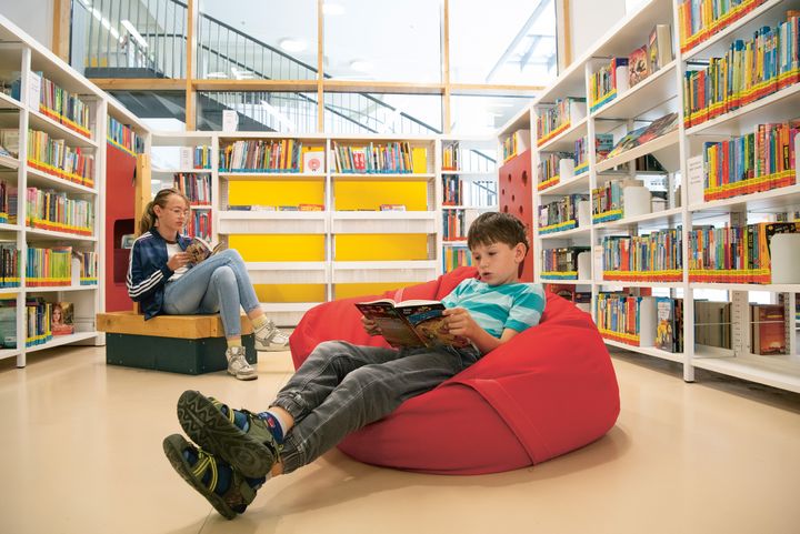 Kinder lesen in der Bibliothek.