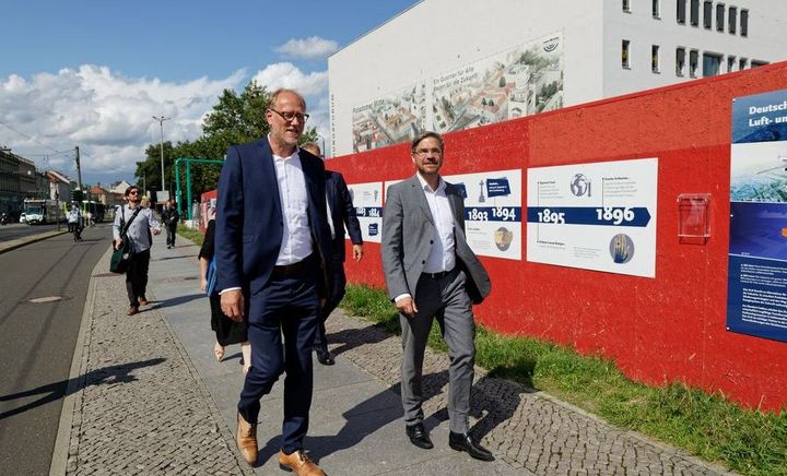Spaziergang durch die Potsdamer Mitte Zwei Männer im Anzug spazieren durch den städtischen Raum