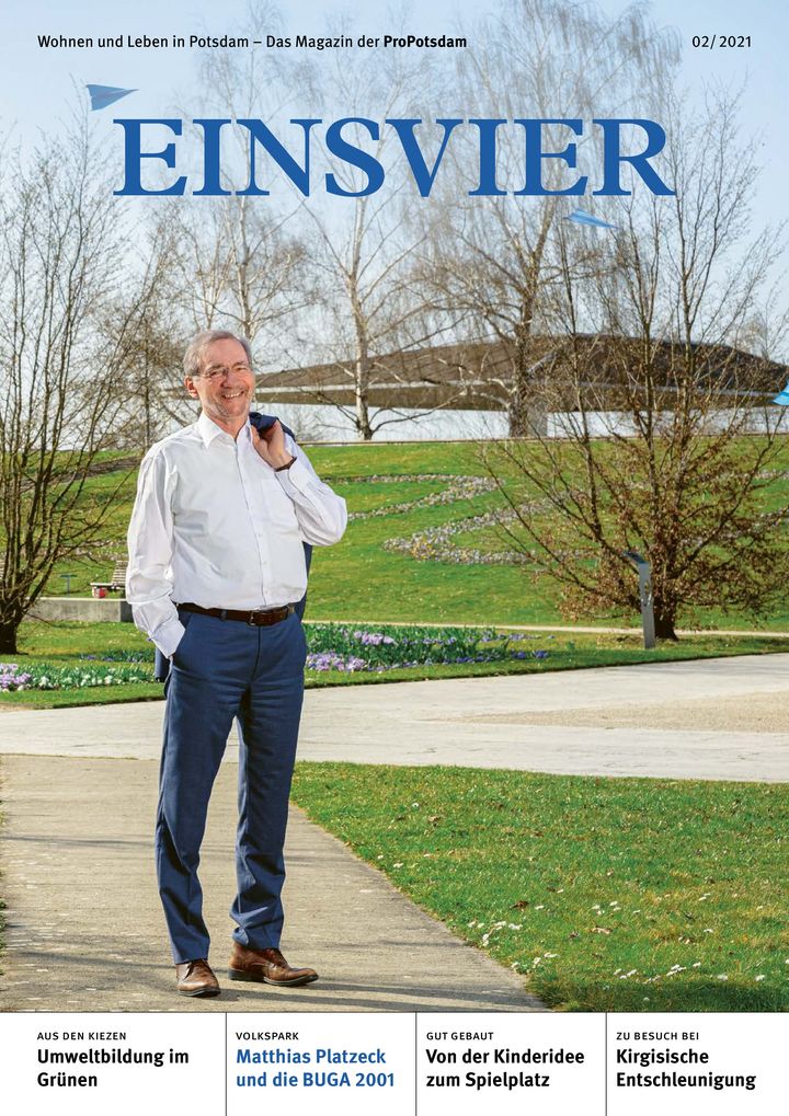 Magazincover mit dem Titel EINSVIER und einem lächelnden Mann mit weißem Hemd, dunkelblauer Hose und Brille