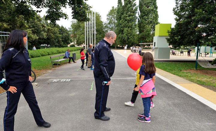 Zwei Polizist*innen unterhalten sich mit zwei Kindern am Spielfeldrand