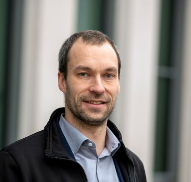 Gregor Heilmann GEWOBA-Geschäftsführer Gregor Heilmann in schwarzer Jacke und blauem Hemd vor unscharfem Hintergrund