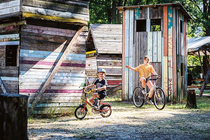 Zwei Kinder fahren Fahrrad über den Spielplatz