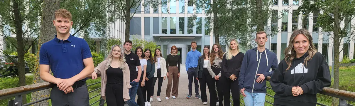 Auf dem Foto stehen mehrere junge Menschen, im Hintergrund ist ein Haus zu sehen