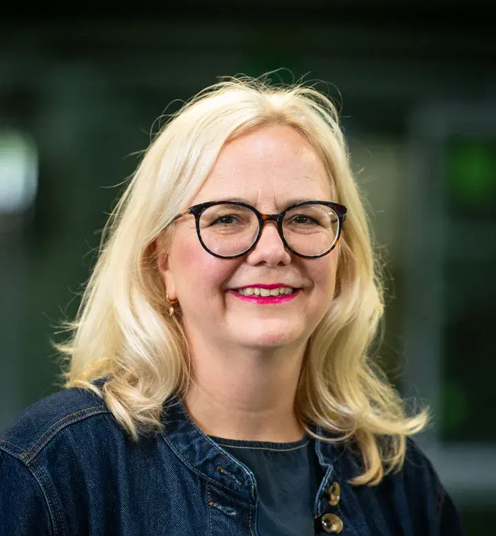 Eine Frau mit mittellangen blonden Haaren und Brille