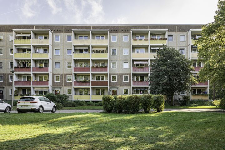 Fünfetagiger Plattenbau mit Wise und Bäumen davor