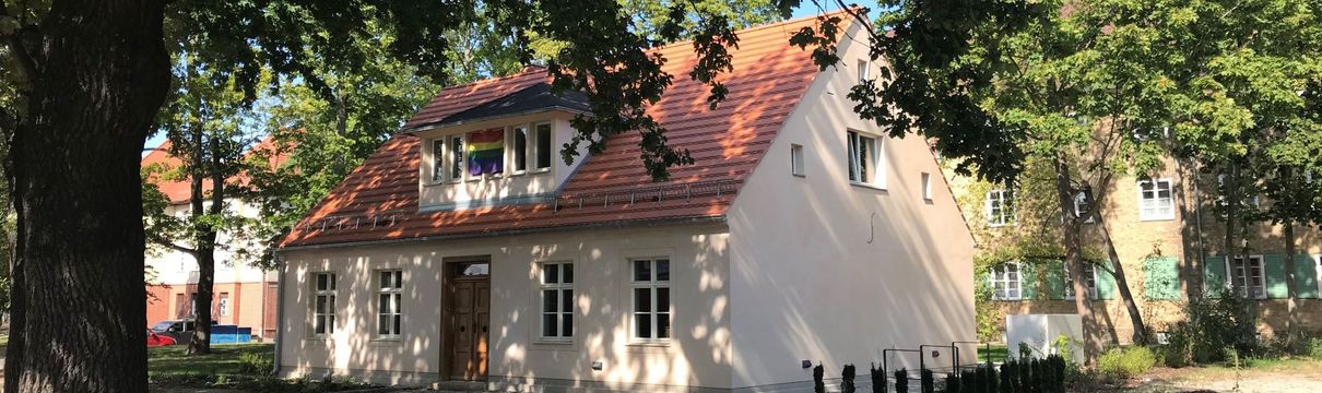 Das Bild zeigt das sanierte Heidehaus und Bäume.