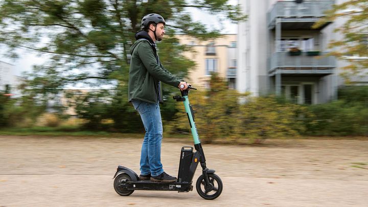 Mann, der mit einem eRoller durch Potsdam fährt