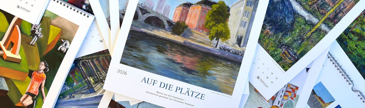 Viele offene Kalender liegen auf einem Tisch verteilt und zeigen unterschiedliche Kalenderblätter mit Kunstwerken.