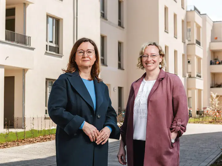 Sandra Jacob und Cindy Plateo vor dem Neubauensemble in der Georg-Hermann-Allee Zwei weibliche Personen stehen vor einem Neubauensemble mit Balkonen