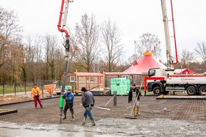 Bauarbeiter arbeiten, im Hintergrund steht das Zelt des Circus Montelino. 