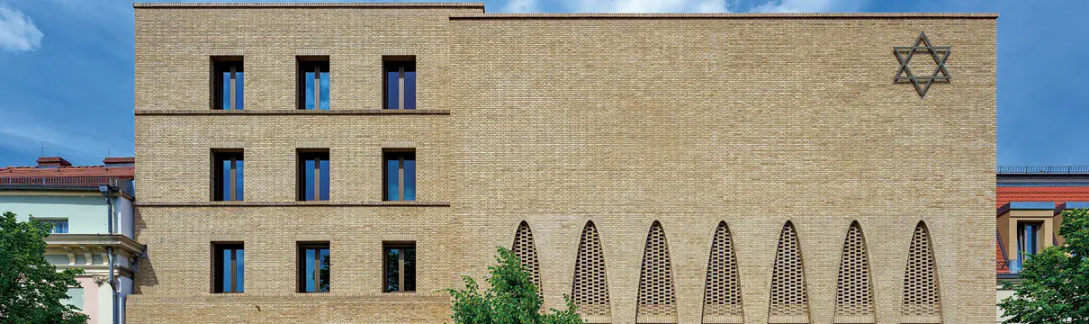 Ein Gebäude aus sandfarbenen Ziegelsteinen mit einen großen Davidstern an der Fassade.