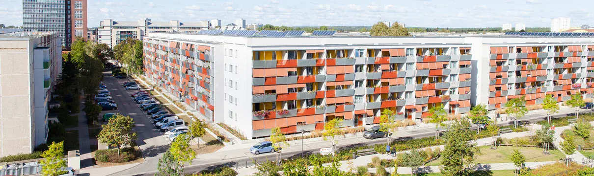 Eine Quartier mit Häusern und einem grüner Park davor.