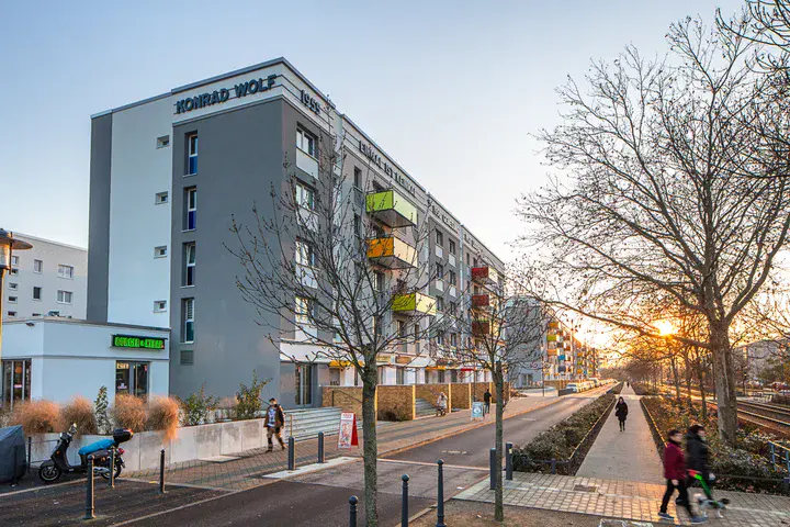 die aufgehende Sonne strahlt auf die bunten Balkone an der sogenannten "Rolle" in der Konrad-Wolf-Allee